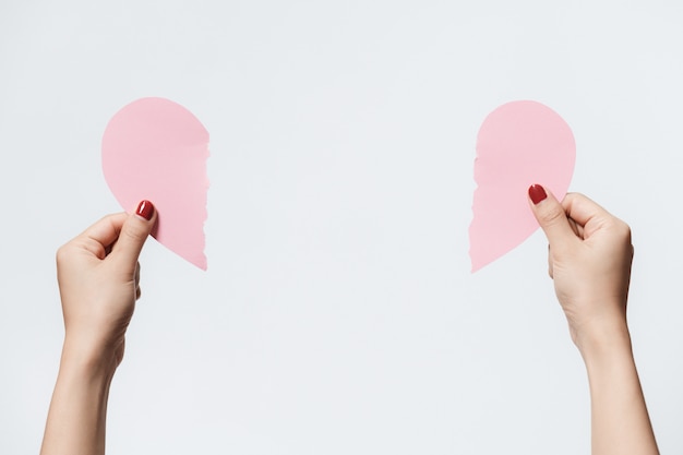 Women holding heart shape paper on white background