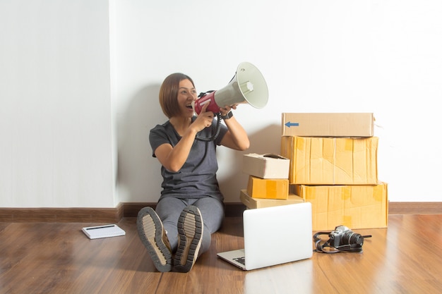 Women holding megaphone with laptop computer from home