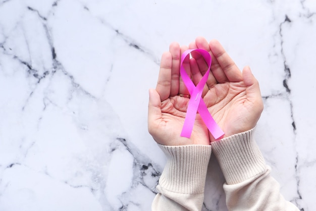 Donne che tengono il ribon di colore rosa, mese di consapevolezza del cancro al seno.