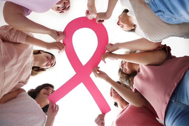 Photo women holding pink paper ribbon bottom view breast cancer awareness concept