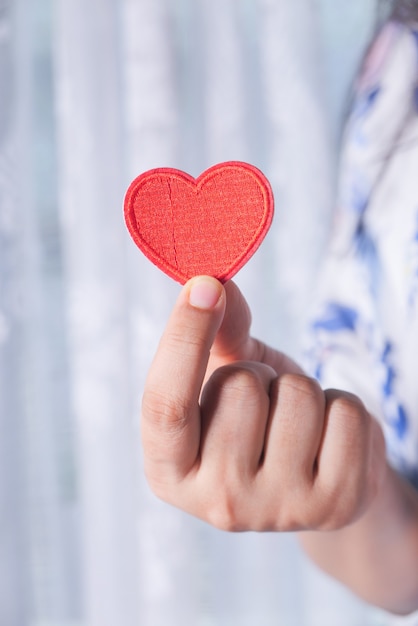 Photo women holding red heart in hands close up