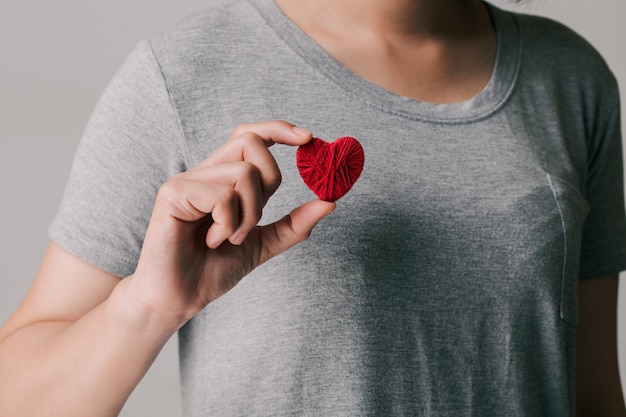 Women holding and showing a red heart.international or national cardiology day.