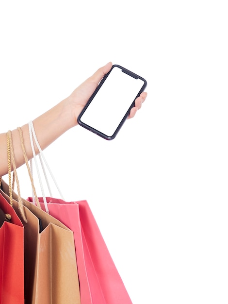 Women holding smartphone with blank screen and shopping bags on white wall