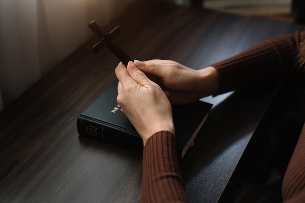 Women holds bible in hands reading the holy bible in home\
concept for faith spirituality and religion peace hope