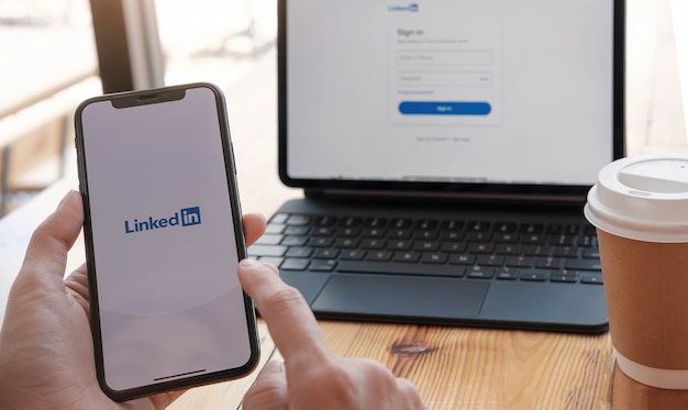 Photo a women holds smartphone with linkedin application on the screen