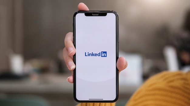 2020년 12월 12일 태국 치앙마이: 한 여성이 화면에 LinkedIn 애플리케이션이 있는 Apple iPhone Xs를 들고 있습니다. LinkedIn은 스마트폰용 사진 공유 앱입니다.