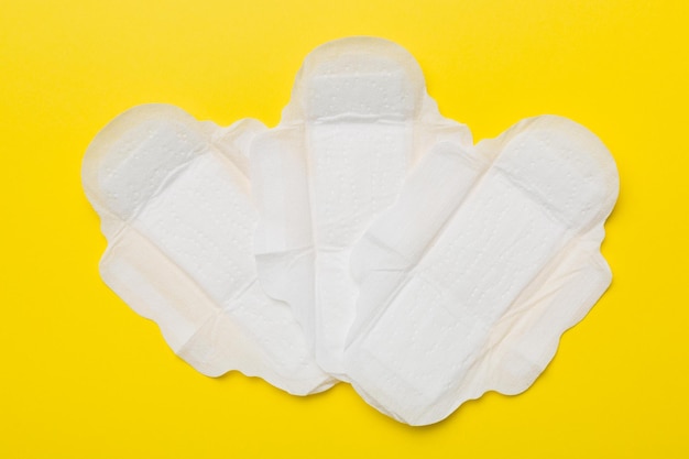 women hygiene products or sanitary pad on colored background pastel color closeup empty place for text female daily hygiene