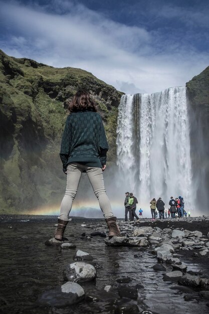 毎日何百人もの観光客が訪れる有名な滝の女性たちが川から写真を撮ります