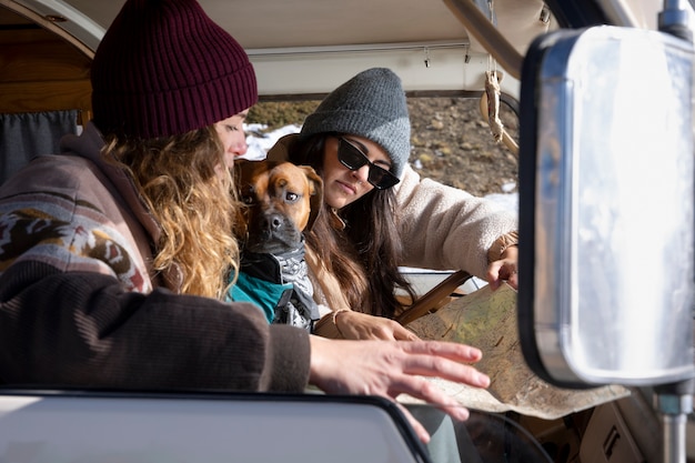 사진 개와 함께 지도를 참조하는 캠핑카 안에 있는 여성