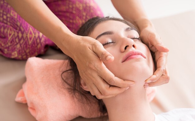 Women is getting face and head massage in Thai Massage course