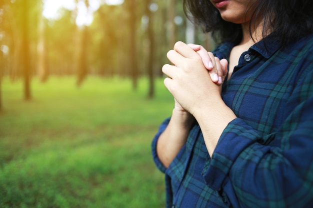 女性は自然の中で神に祈ります。