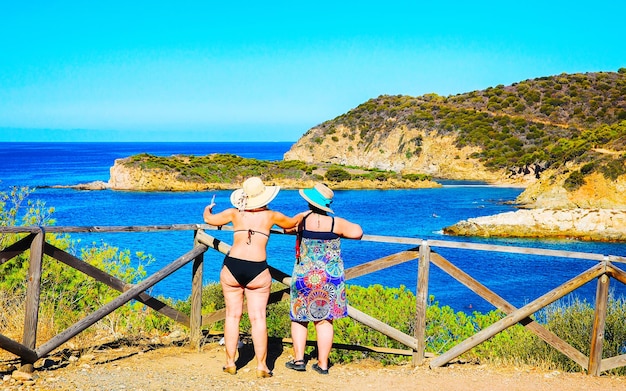 Women and Landscape of Chia Beach and Blue Waters of the Mediterranean Sea in Province of Cagliari in South Sardinia in Italy. Scenery and nature. Mixed media.