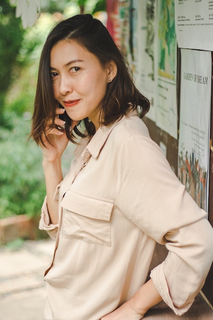 Women leaning against wooden walls and talking on the phone