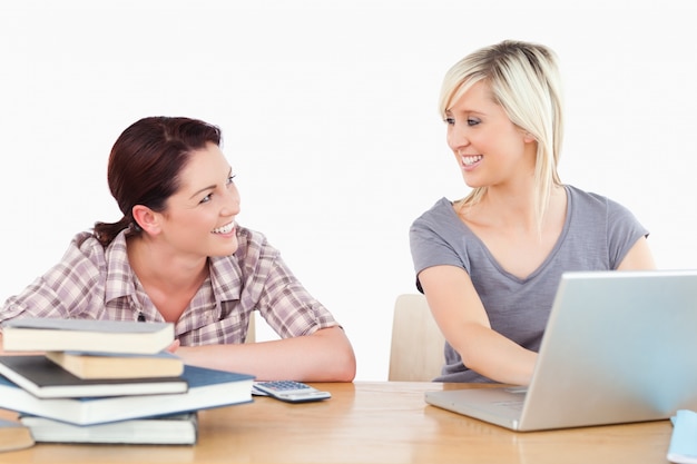 Women learning with laptop and books