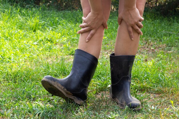 Women legs in black rubber boots on the background