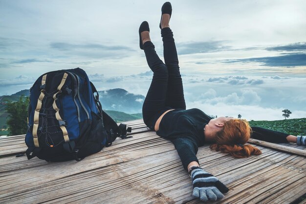 Women lying on wood against landscape