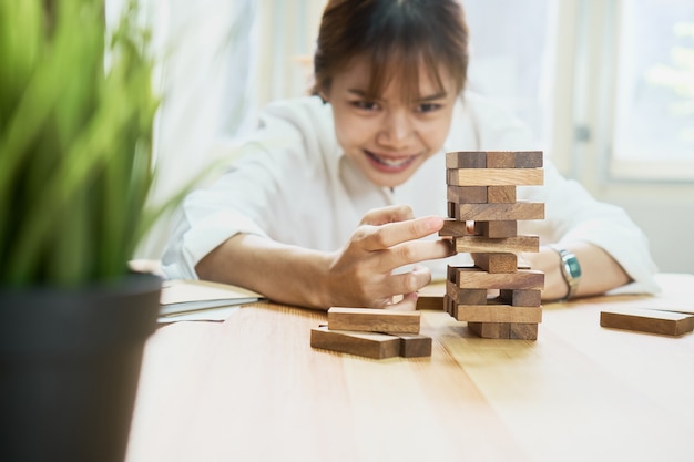 空の木製立方体でピラミッドを作る女性