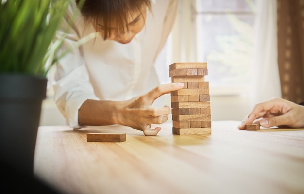 空の木製立方体でピラミッドを作る女性