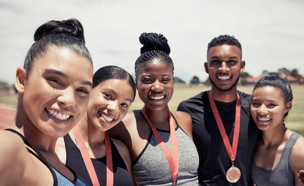 Women man and running track team with medals in fitness workout or training marathon sprint event or competition race Portrait happy smile or winner runners with sports award or exercise prize