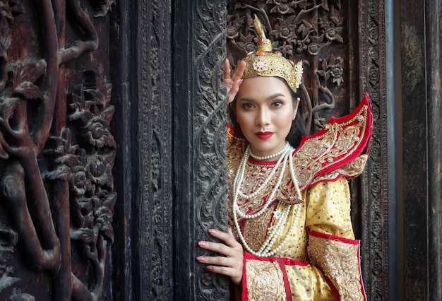 Women in Mandalay Traditional Costume standing by wooden door