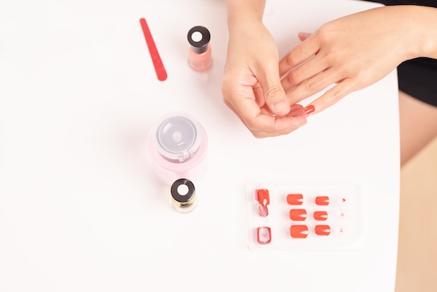 women manicure and attaches nail shape with gel Fashion and Beauty concept