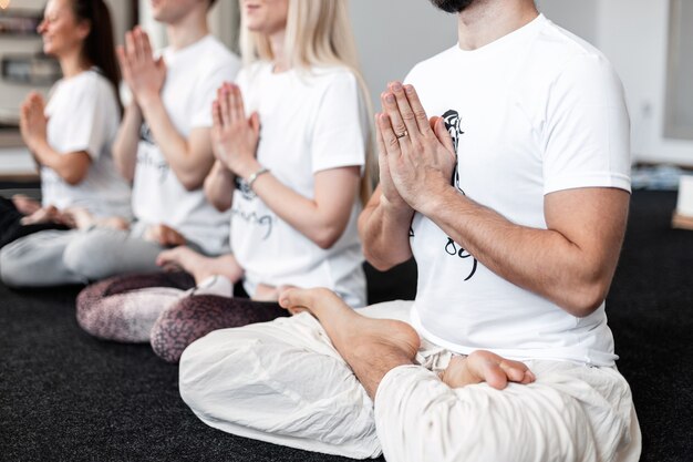 Photo women and men sits in a lotus position and meditates in yoga classes. concept sports and healthy lifestyle.