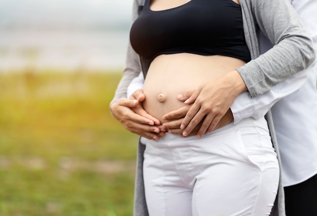 Women and men touch the belly, showing love for the baby in the stomach