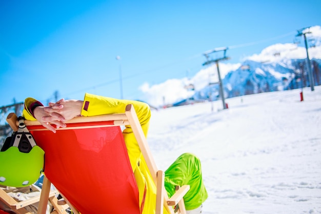 Women at mountains in winter lies on sun-lounger