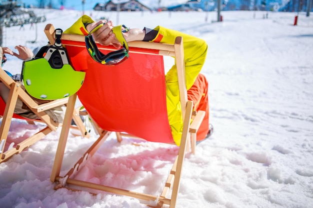 Women at mountains in winter lies on sun-lounger