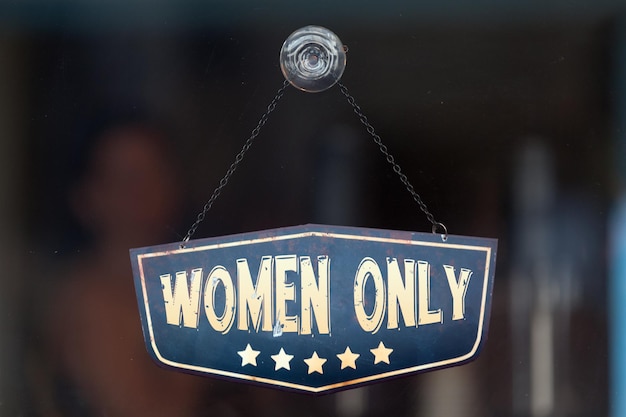 Women only sign in the window of a shop