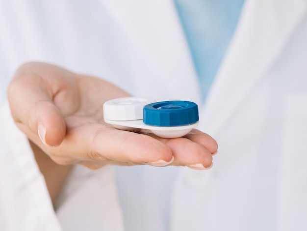 women ophthalmologist holding a pair of contact lenses