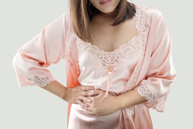 Foto una donna con una camicia da notte arancione ha sintomi di dolori addominali e crampi mestruali