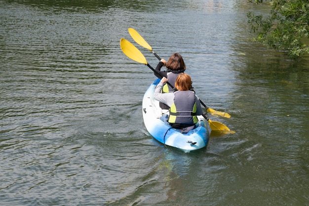 Women paddeltour kayak with paddle boats in Clain river in France