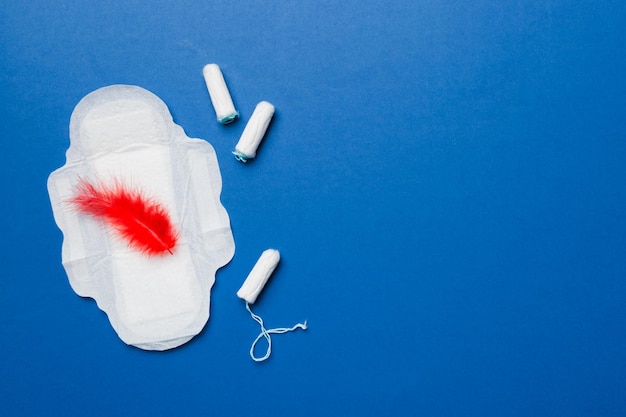 Women pads and tampon sanitary pads lies next to a tampon on an isolated background on a pink and violet background Women's hygiene and menstrual period concept