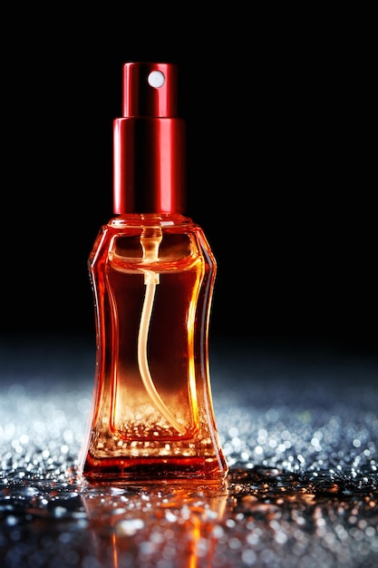 Women perfume in beautiful bottle on dark background