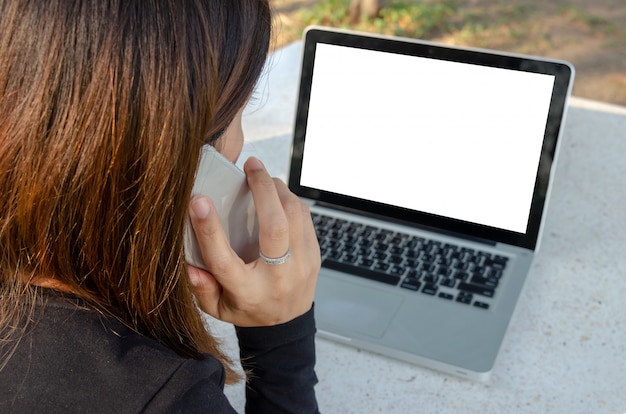 女性の携帯電話とラップトップ