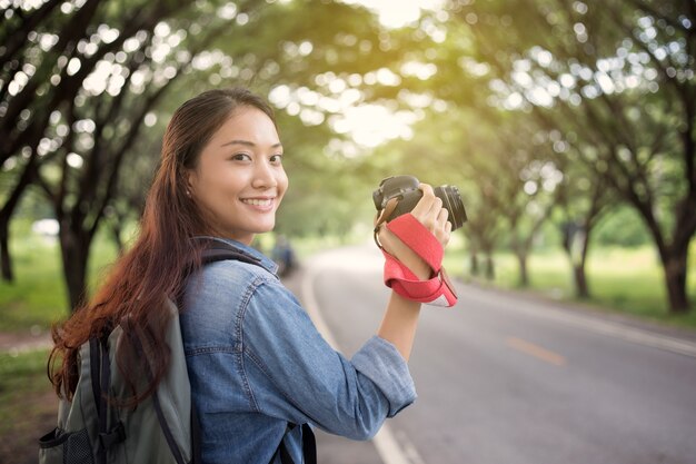 野生のカメラを持っている女性の写真家が観光客の写真を撮る