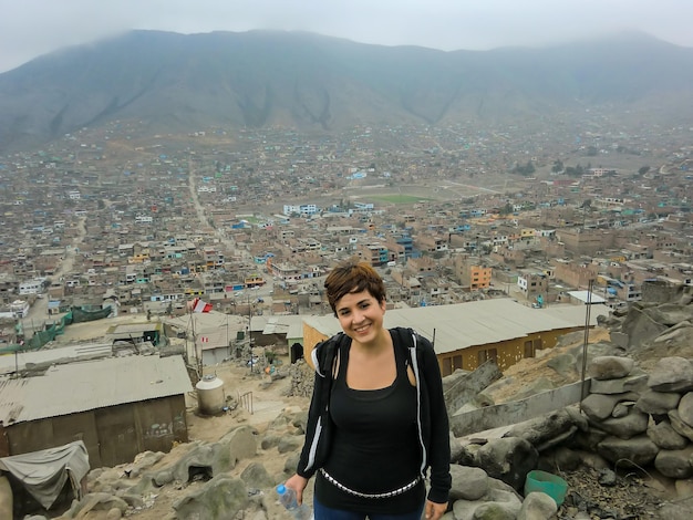 Photo women posing from the top of a hill populated by houses in colliqueperu
