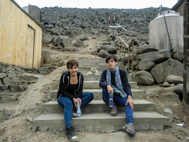 Women posing from the top of a hill populated by houses in ColliquePeru