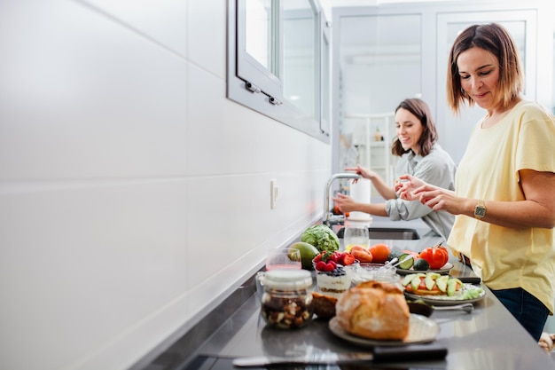 women preparing food at kitchen