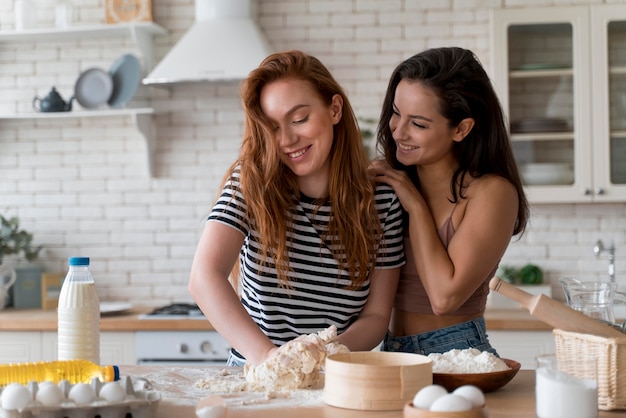 Donne che preparano insieme una cena romantica a casa