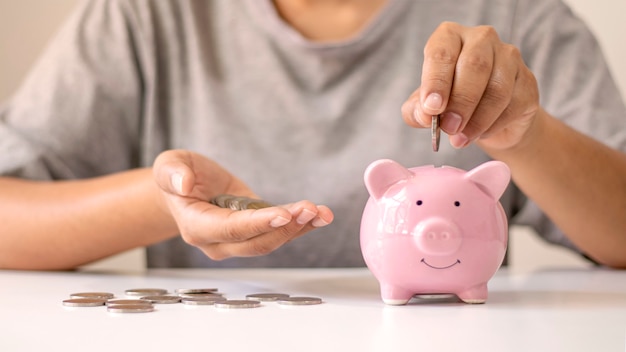 Women put silver coins into piglets to save money