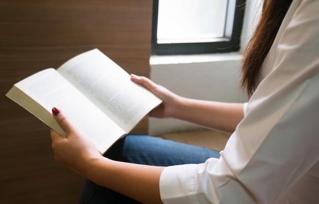 写真 女性が本を読んで、図書館でリラックスする選択的なフォーカス