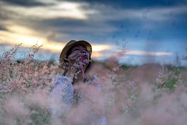 Photo women relax and enjoy play bubbles in the flower meadow