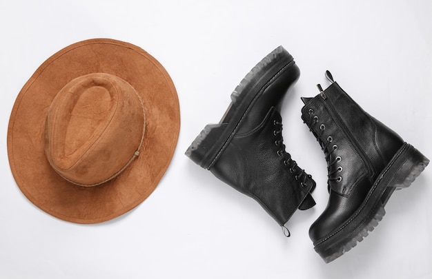 Women's accessories Black Leather boots and hat on white background Top view Flat lay