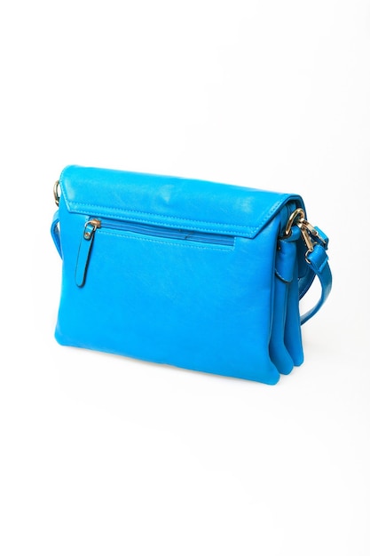 긴 손잡이가 있는 여성용 파란색 가죽 가방은 흰색 배경에 분리되어 있습니다.