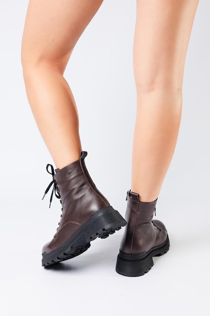 Women's brown spring boots made of genuine leather on a woman's leg New collection of women's boots 2022