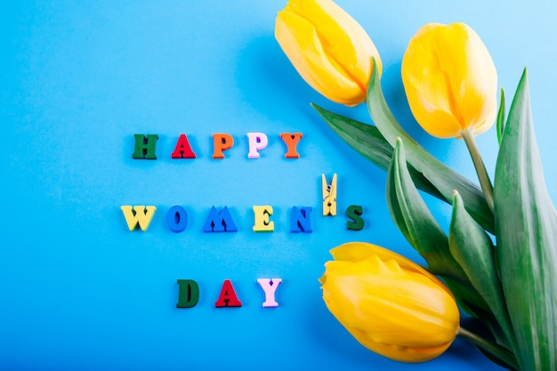 Women's day lettering with yellow tulips