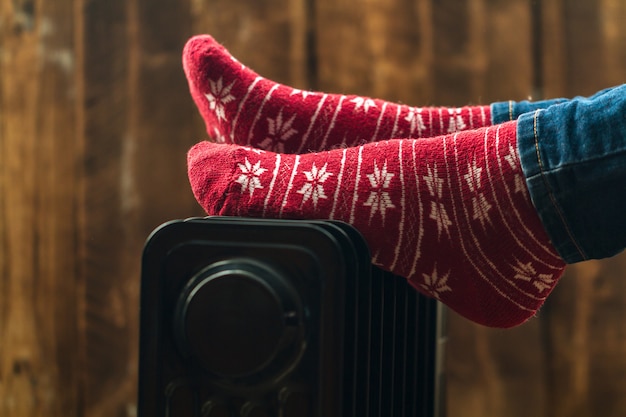 크리스마스에 여자의 발, 히터에 따뜻한 겨울 양말. 겨울, 추운 저녁에는 따뜻하게 유지하십시오. 난방 시즌