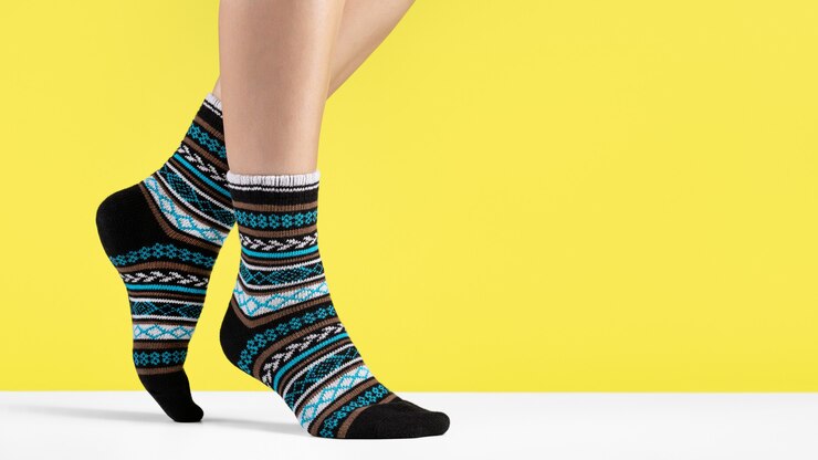 Women's feet have warm knitted socks with an ornament